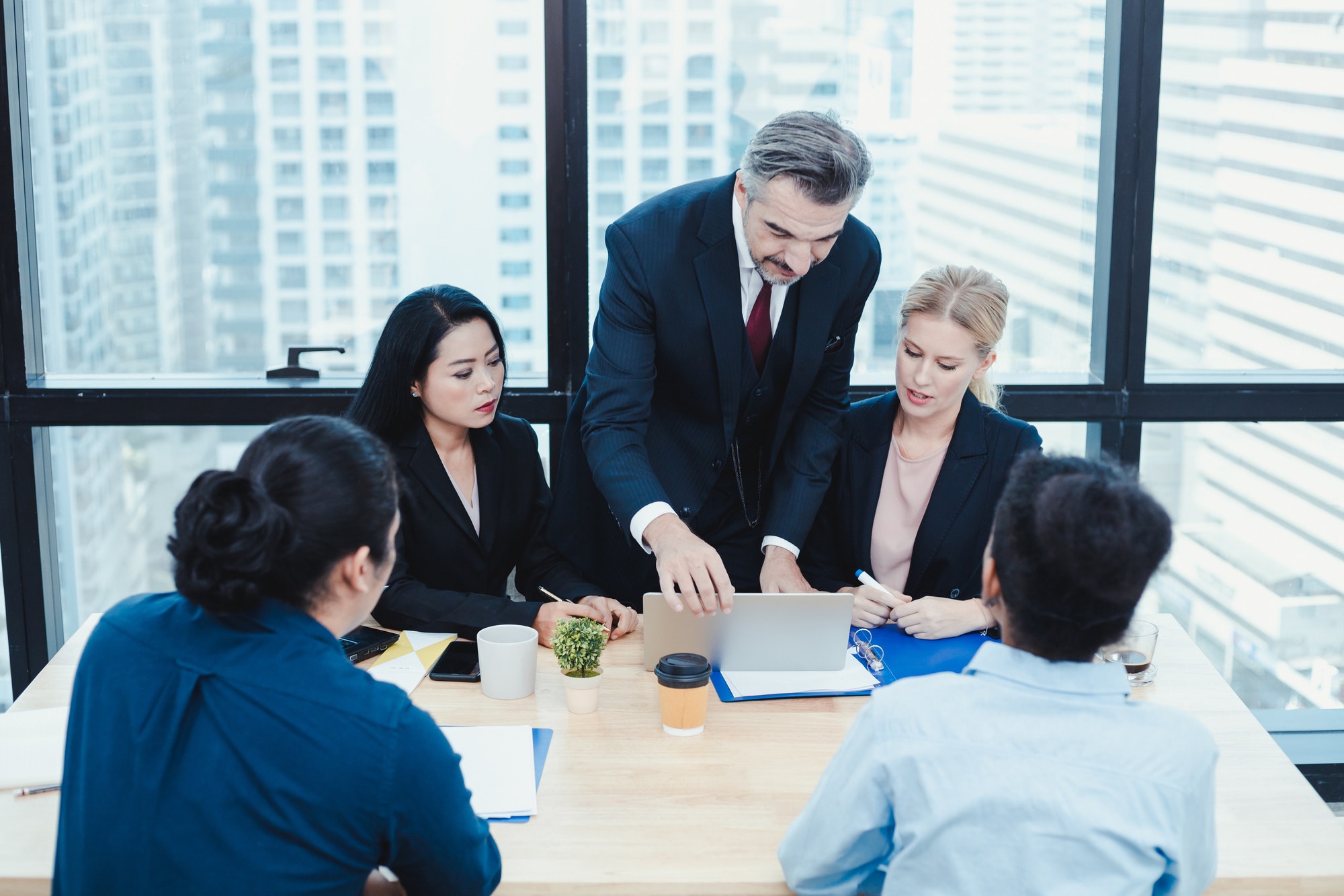 Business team and manager in meeting room.